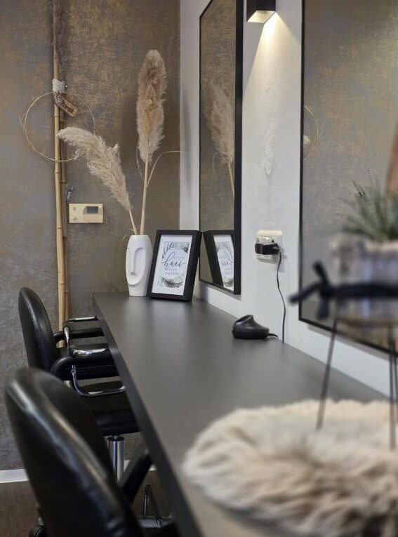 Detailaufnahme des Salonbereichs mit Spiegeln und stilvoller Dekoration